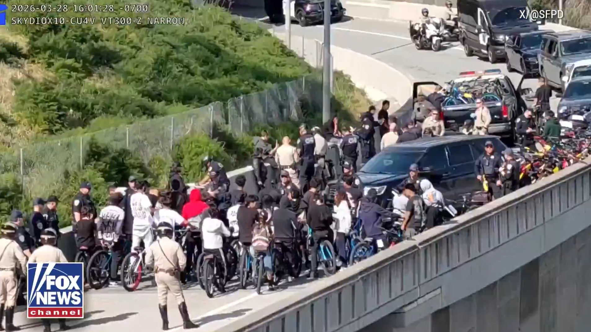 Bicyclists and police on an overpass