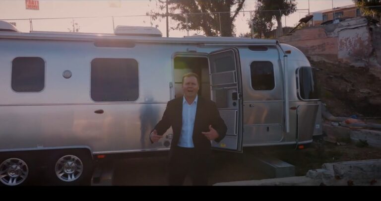 Spencer Pratt standing in front of trailer