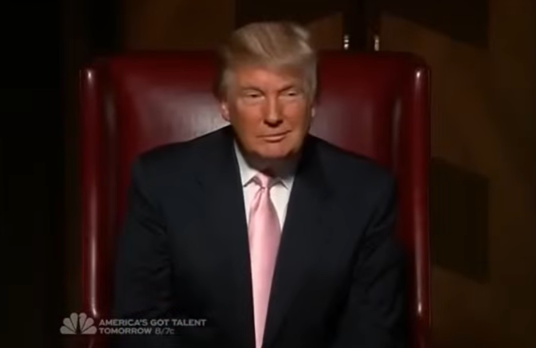 Donald Trump sitting in his chair on the show The Apprectice