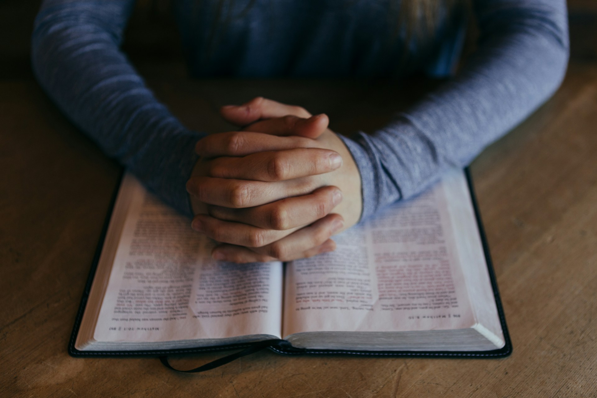 A bible with someone praying